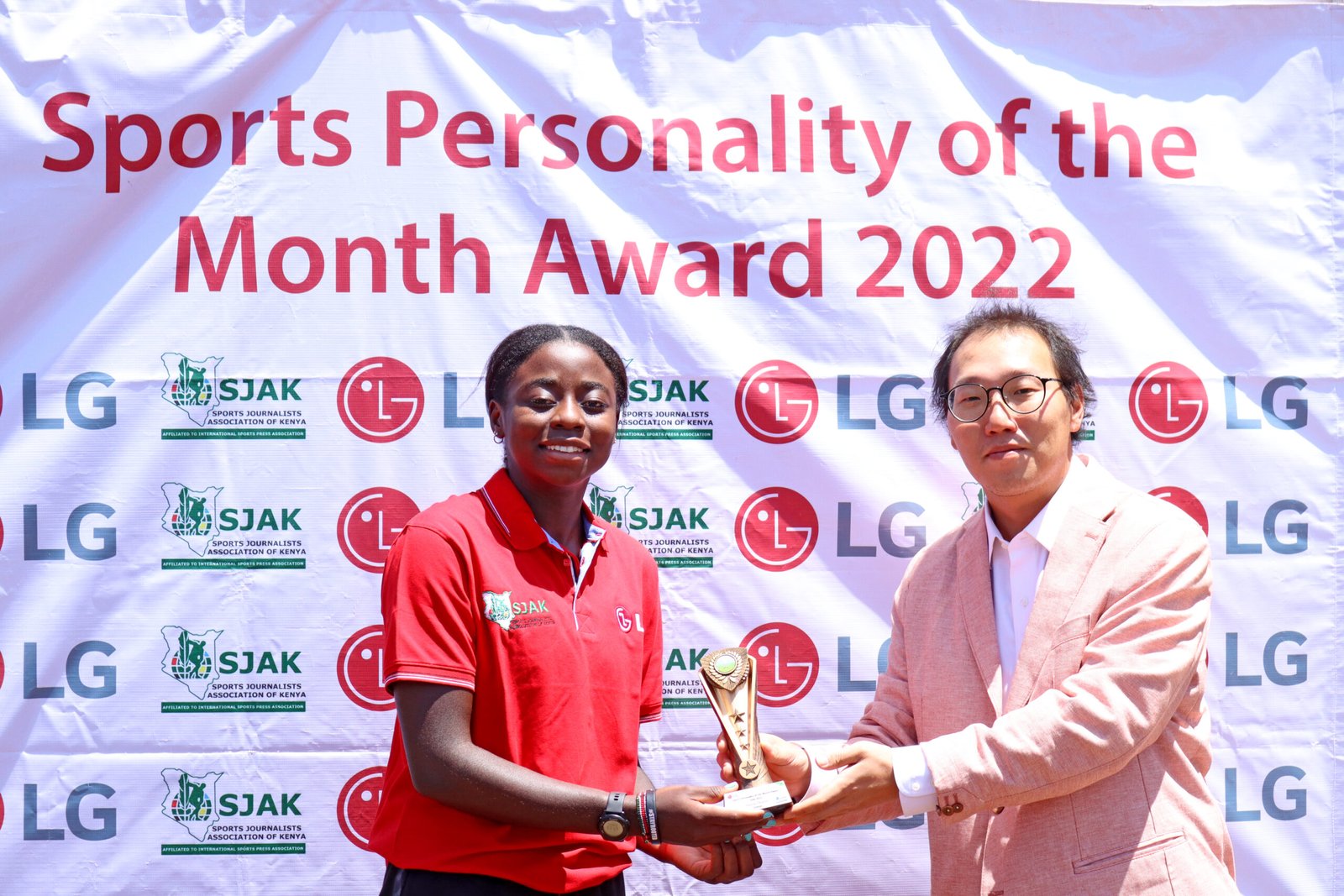 Angela Okutoyi receives the July monthly award from LG Electronics EA Marketing Director Changhyun Kim scaled