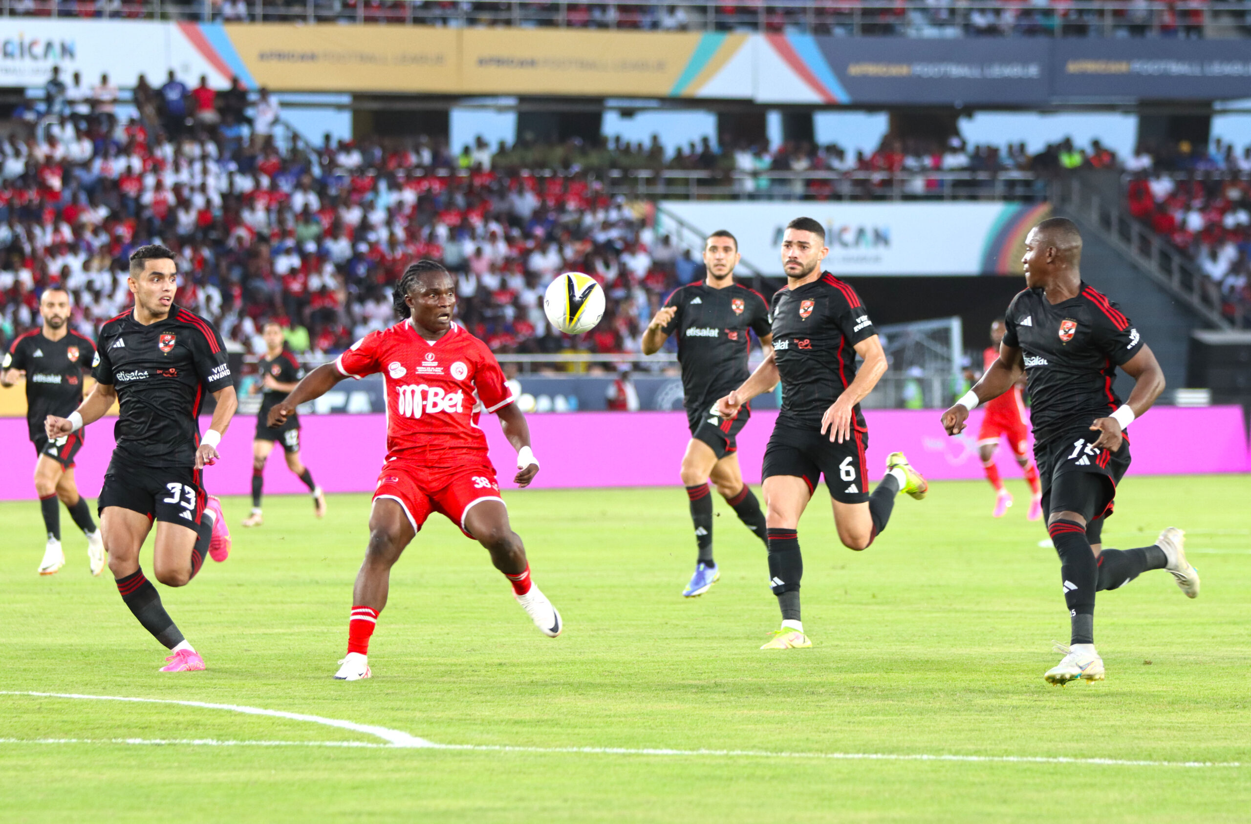 Simba's Dennis Kibu controls the ball under pressure from Ahly defenders