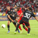 Simba's Clatous Chama attempts to find a way past Al Ahly defenders