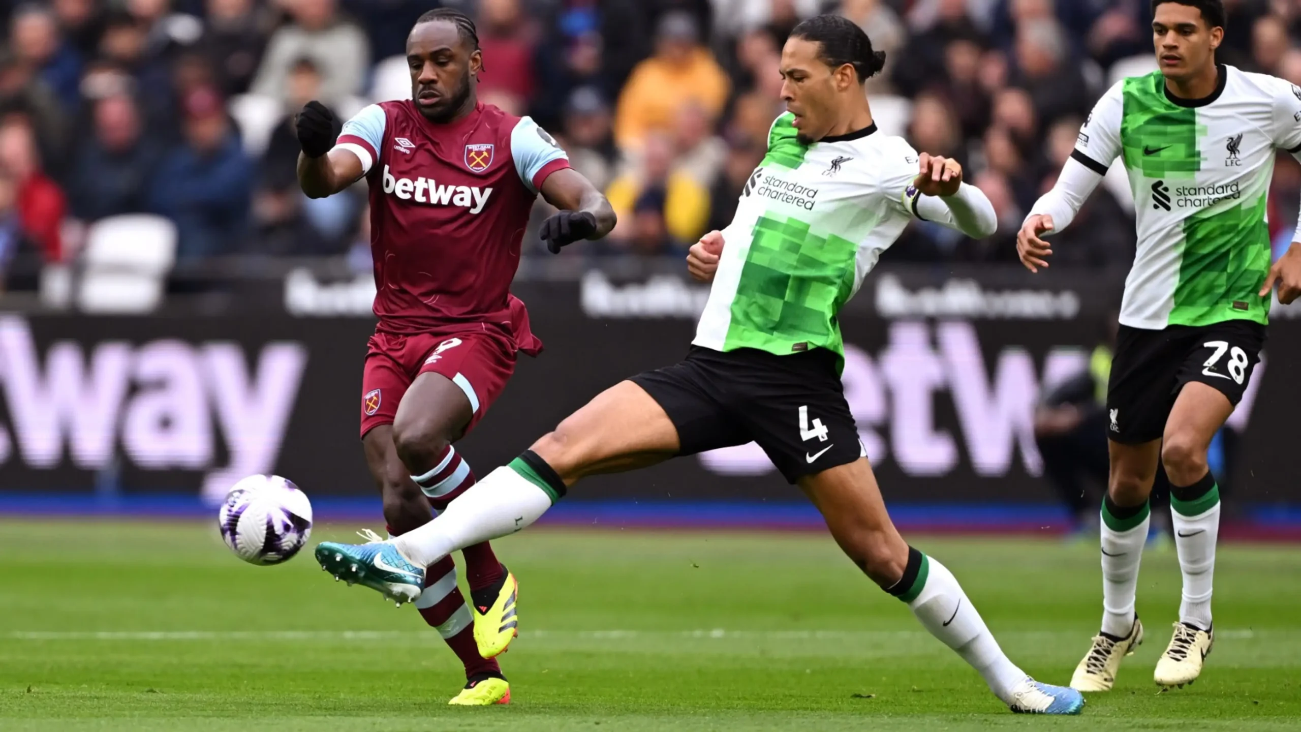 Van Dijk battles the ball with Michail Antonio. 